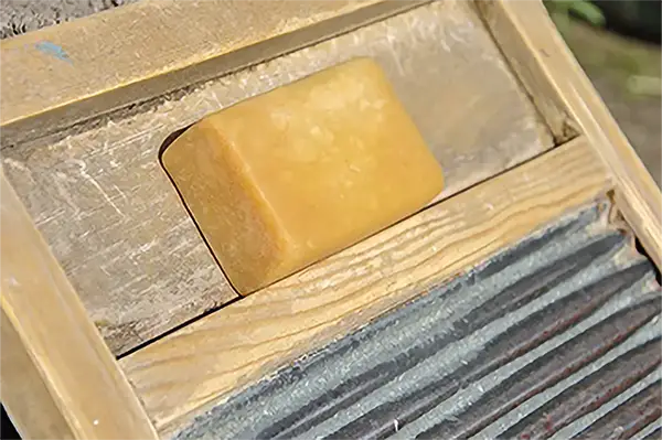 A bar of old-fashioned lye soap on a washboard