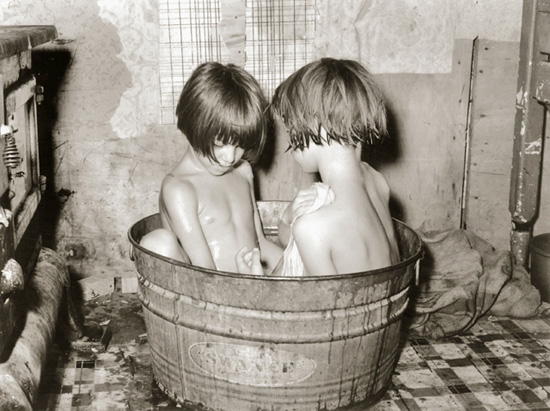old-fashioned photo of kids bathing in a wooden tub