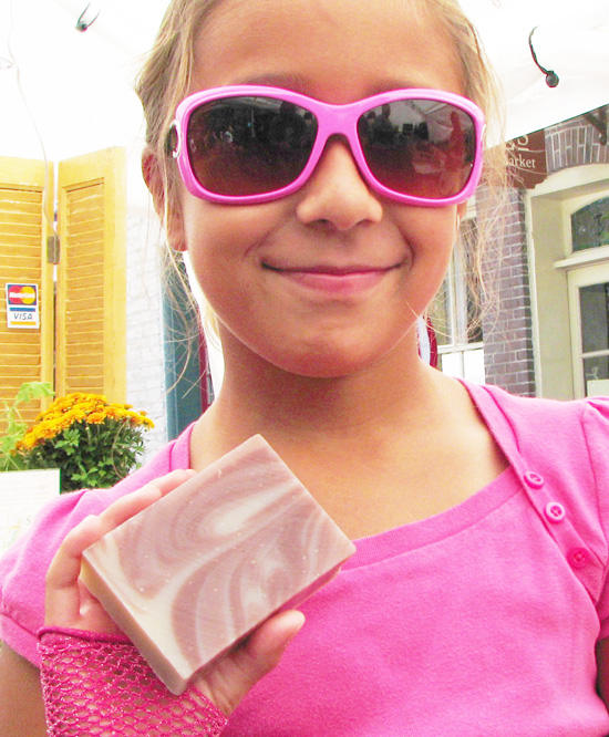young girl in pink holding Herbaria Peppermint soap photo