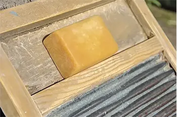 A bar of old-fashioned lye soap on a washboard