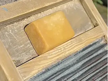 A bar of old-fashioned lye soap on a washboard