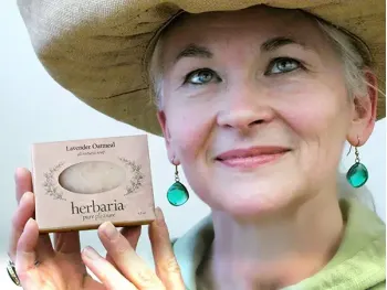 Paulette an older woman holding Herbaria Soap's most popular Lavender Oatmeal