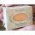 Close-up view of a large Herbaria "Citrus Oatmeal" all-natural soap bar in its kraft paper branded packaging, held in someone's hands to show scale.
