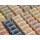 Rows of various Herbaria handmade all natural half-bar soaps view fromt he top down. Soaps are displayed on a wooden shelf.