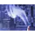 Wisps of blue-toned smoke curling upward from a lit herbal incense stick.