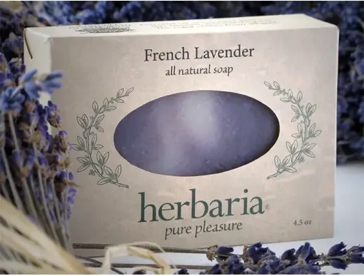 Herbaria's Handcrafted French Lavender soap bar with natural purple hues from alkanet surrounded by botanicals.