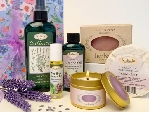 Herbaria natural lavender gift set featuring handmade soap, candle, bath bomb, almond oil, room spray, and headache oil in a floral wrapping paper.
