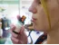 Close-up profile of Herbaria employee Bekka holding a small amber glass bottle up to her nose to smell the essential oil.