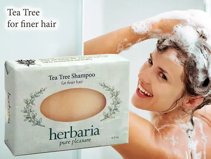 Herbaria Tea Tree Shampoo bar for finer hair with a woman lathering her hair in the shower.
